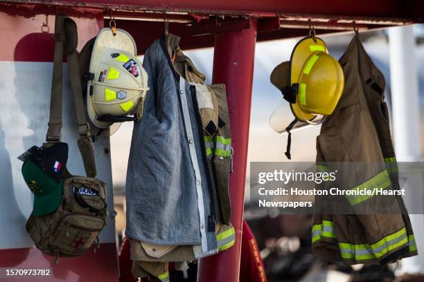 Fire helmets and bunker gear hang near a fire training simulation at Disaster City on Wednesday, July 10 in College Station.