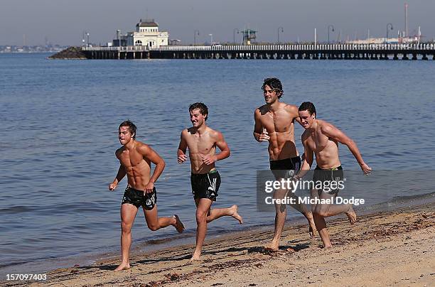 Ben Kennedy, Tim Broomhead, Brodie Grundy and Jackson Ramsey run along the beach during a Collingwood Magpies AFL training session at St Kilda Sea...