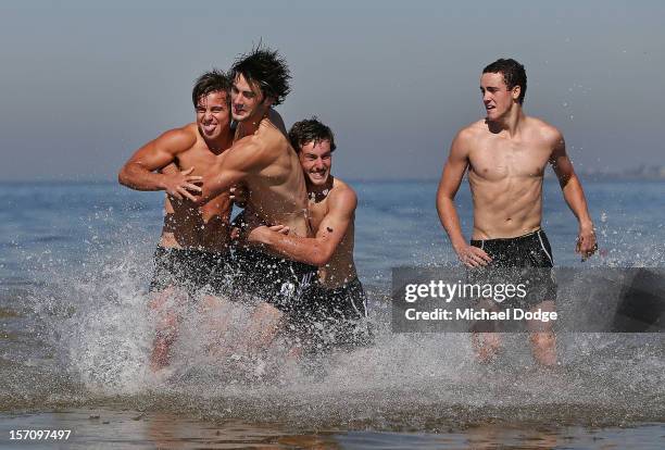 Ben Kennedy, Brodie Grundy, Tim Broomhead and Jackson Ramsey play around during a Collingwood Magpies AFL training session at St Kilda Sea Baths on...