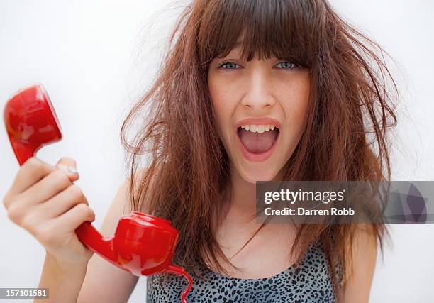 young woman holding a telephone, screaming - hormone stock-fotos und bilder