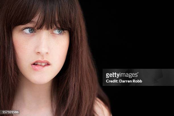 a young woman biting her lip, close-up portrait - biting lip ストックフォトと画像