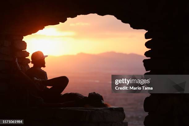 People gather and watch the sunset from South Mountain Park amid the city's worst heat wave on record on July 25, 2023 in Phoenix, Arizona. While...