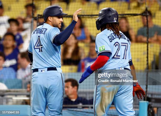 George Springer and Vladimir Guerrero Jr. #27 of the Toronto Blue Jays celebrate scoring against the Los Angeles Dodgers in the ninth inning at...