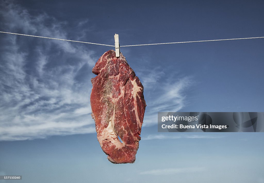 A steak hanging to dry on a washing-line