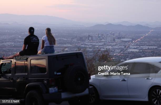 People take in the view from South Mountain Park after sunset amid the city's worst heat wave on record on July 25, 2023 in Phoenix, Arizona. While...