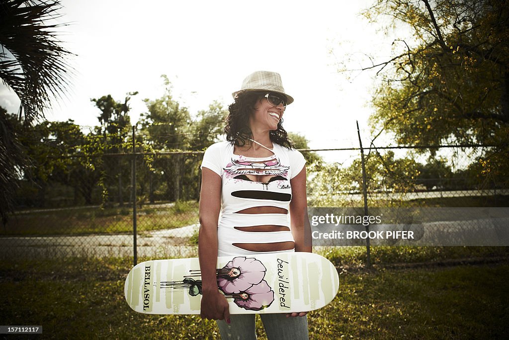 Young woman holding skateboard