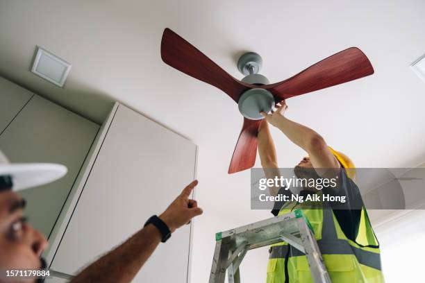 técnico instalando ventilador de techo de madera en cocina - asian ceiling fotografías e imágenes de stock