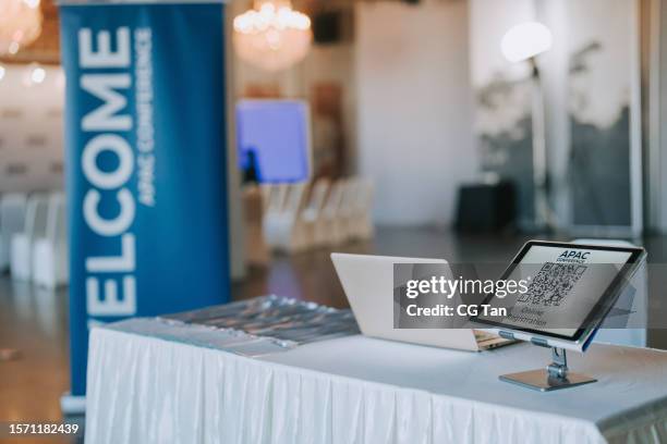 apac registration counter with digital tablet display qr code for self check in at hotel business conference entrance hall - shareholders meeting stock pictures, royalty-free photos & images