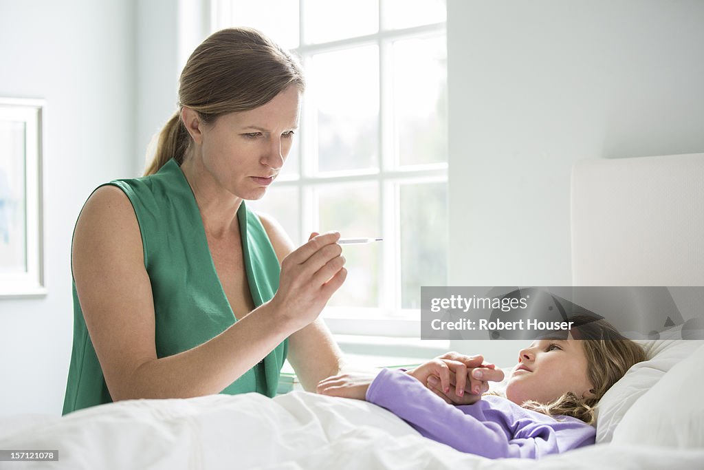 Mother takes daughter's temperature