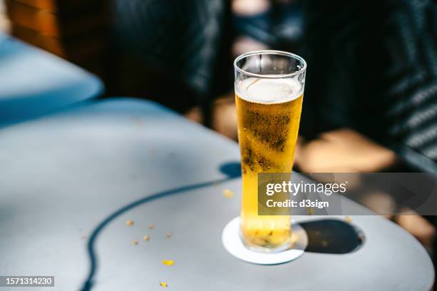 glass of cold beer on a table in outdoor restaurant in sunlight. food and lifestyle concept - bière photos et images de collection