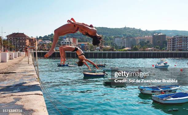 teenage girls jumping with their backs into the water - südamerikanisch stock-fotos und bilder