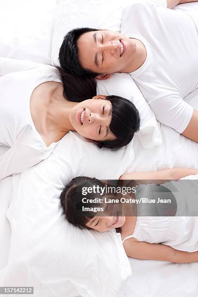 happy family lying in bed - bed on white stock pictures, royalty-free photos & images