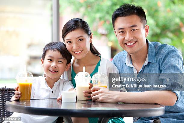 family enjoying cold drink together - asian family cafe stockfoto's en -beelden