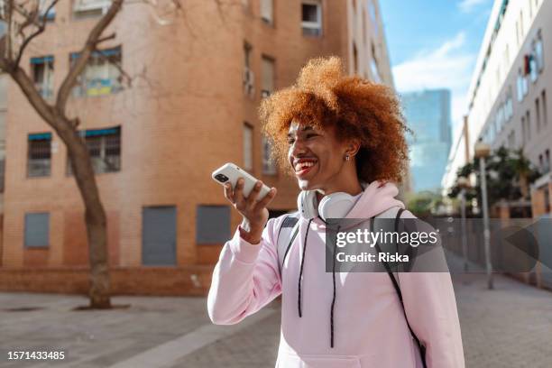 an african american man in the city, on a spring day - speech recognition stockfoto's en -beelden