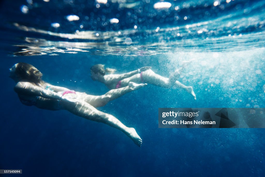 Two young women swimming underwater