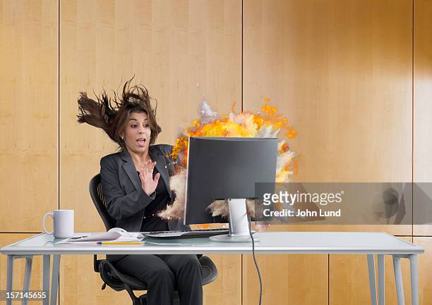 a woman recoiling as her computer explodes - computer failure stock pictures, royalty-free photos & images