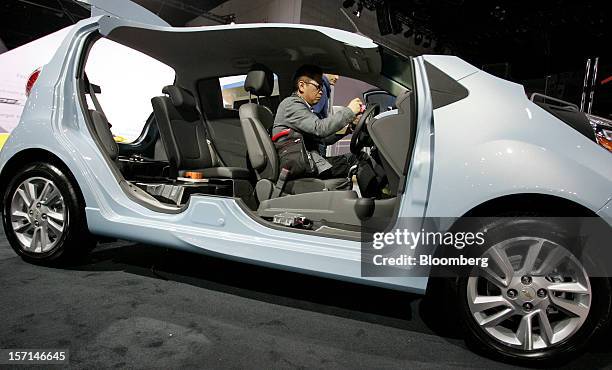 An attendee sits inside a display vehicle at the General Motors Co. Chevrolet stand during the LA Auto Show in Los Angeles, California, U.S., on...