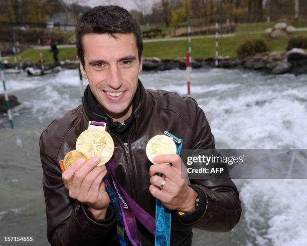 French legendary slalom canoeist Tony Estanguet poses with his three Olympic medals in front of the Gave de Pau river in Pau, southwestern France, on...