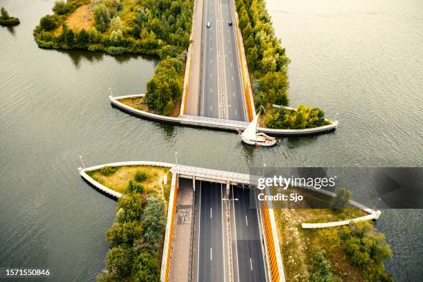 aqueduct veluwemeer in the veluwe lake with a boat sailing in the canal - aqueduct stockfoto's en -beelden