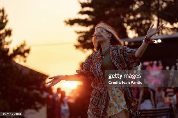 happy hipster woman enjoying on an outdoor music festival at sunset. - techno stockfoto's en -beelden