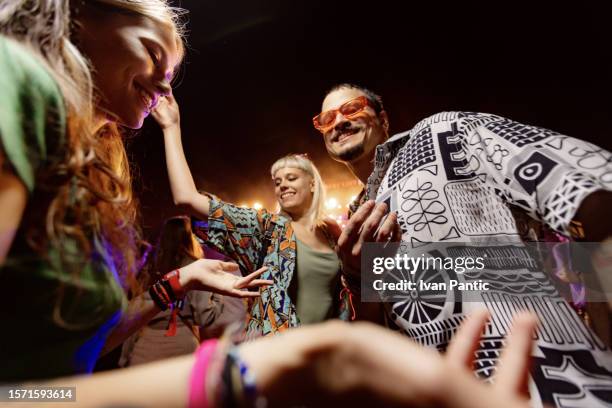 abajo vista de amigos felices bailando en concierto de música por la noche. - techno fotografías e imágenes de stock