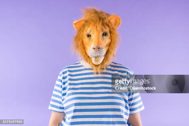 woman wearing striped t-shirt and lion mask on purple background. costume, animal, carnival, party and bizarre concept. - animal ear stock-fotos und bilder