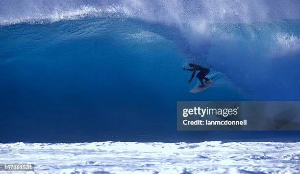 surfer on a blue wave - big wave surfing stock pictures, royalty-free photos & images