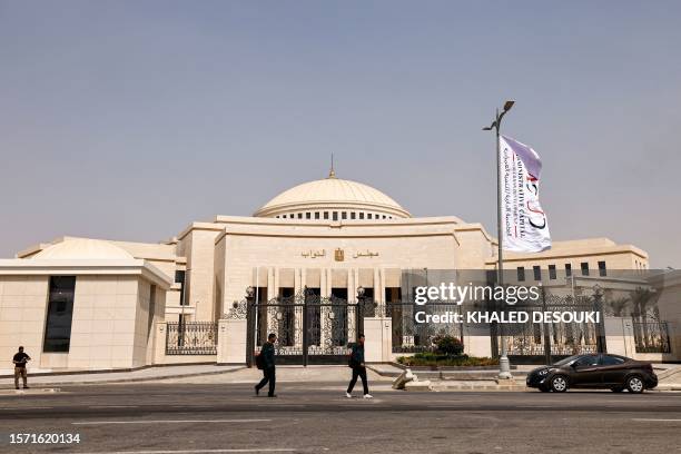 People walk outside the new headquarters for the House of Representatives, the lower house of the Egyptian Parliament, at the New Administrative...
