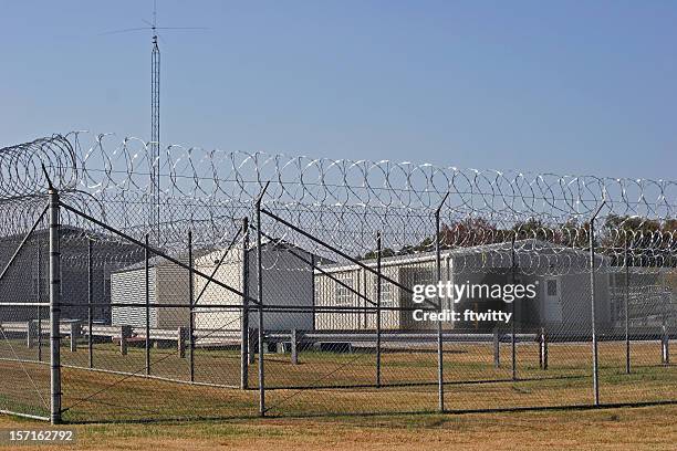 prison barracks - fence with barbed wire stock pictures, royalty-free photos & images