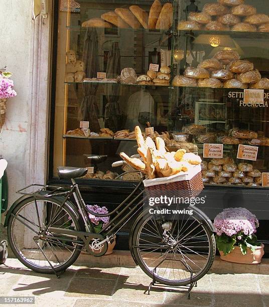 pan entrega en bicicleta con panadería window- pan loaves en la cesta - barra de pan francés fotografías e imágenes de stock