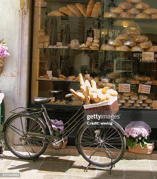 bread delivery bike with bakery window- bread loaves in basket - flute stockfoto's en -beelden