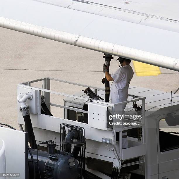 airport worker refuelling an aeroplane before take off - refueling stock pictures, royalty-free photos & images