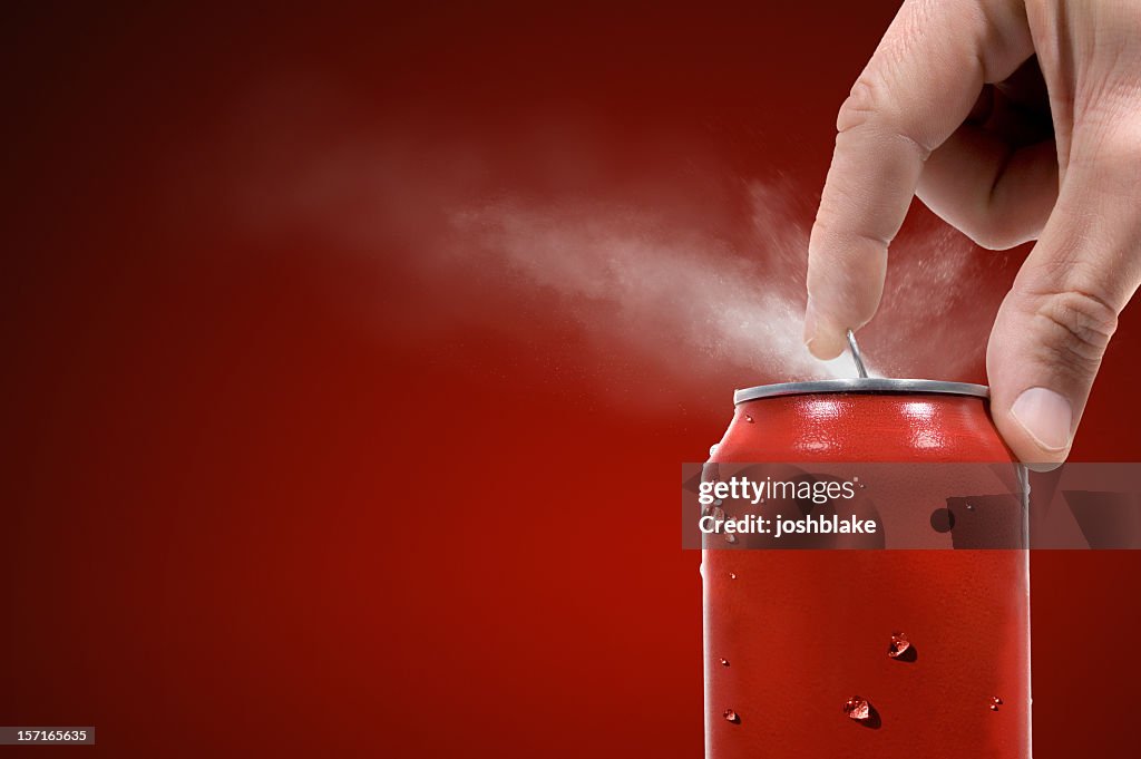 Person opening can of carbonated beverage