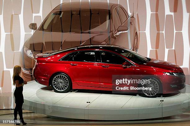 Model stands next to the Lincoln MKZ vehicle during the LA Auto Show in Los Angeles, California, U.S., on Thursday, Nov. 29, 2012. Ford Motor Co.,...