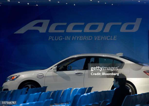 Man sits in front of Honda Motor Co. Accord plug-in hybrid vehicle during the LA Auto Show in Los Angeles, California, U.S., on Thursday, November...