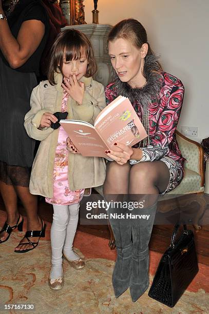 Julia Cattelain and Celia Cattelain attend a catwalk show and auction hosted by Browns, Harpers Bazaar and H.E. Alain Giorgio Maria Economides in aid...