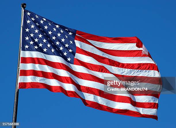 american flag flying high on top of flag pole on a clear day - american flag on a pole stock pictures, royalty-free photos & images