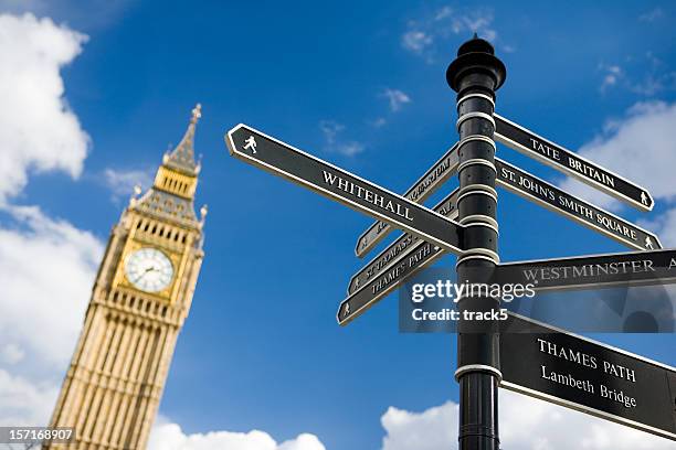 beschilderung in london, mit clock tower im hintergrund. - whitehall london stock-fotos und bilder