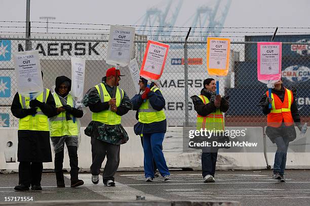 Members of International Longshore and Warehouse Union Local 63 Office Clerical Unit walk a picket line near APM Terminals, halting cargo at the...