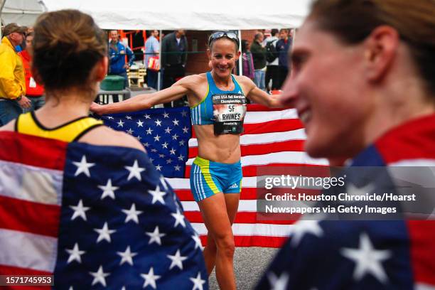 Jen Rhines, 1st place, carries an American Flag as Serena Burla, 2nd place, and Nan Kennard, 3rd place, look on during the Women's 2011 USA Half...