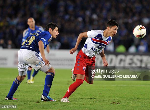Pedro Franco of Colombia's Millonarios vies for the ball with Ruben Botia of Argentina's Tigre during their Copa Sudamericana 2012 semifinal second...