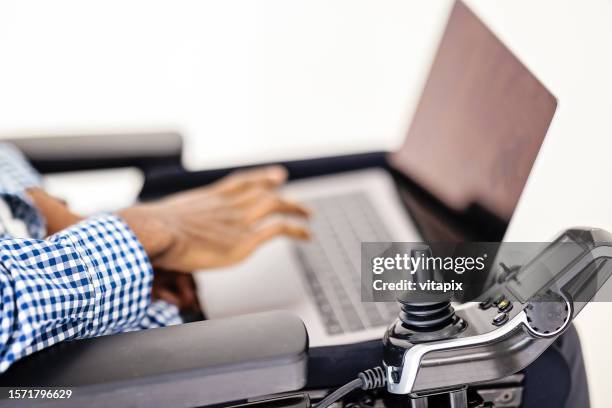 homme en fauteuil roulant travaillant sur un ordinateur portable - handicap photos et images de collection