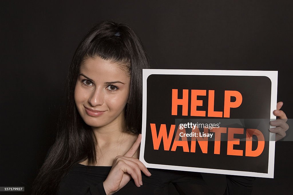 Woman holding a Help Wanted sign