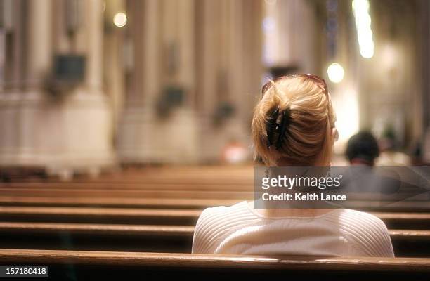 blonde woman sitting on a church bench praying - präst bildbanksfoton och bilder