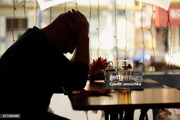 hombre triste sentada en el restaurante - crisis de los cuarenta fotografías e imágenes de stock