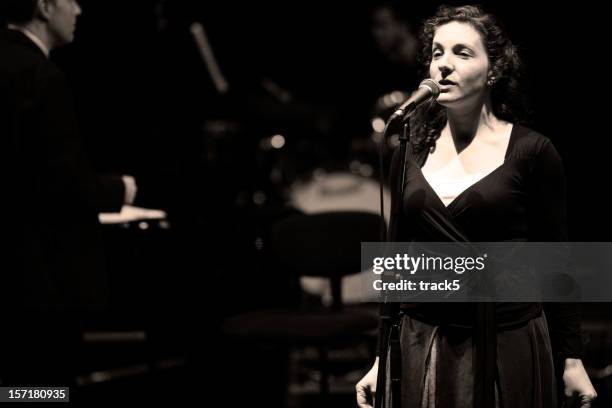 bigband: female jazz singer in performance behind the microphone - opera theatre stockfoto's en -beelden