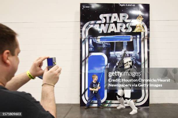 Steve Wilson takes a photo of his son Max as he attacks Adam Barnes, a Storm Trooper from the 501st Legion, as Charles LeBleu takes a photo during...