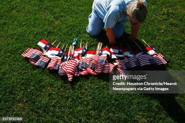 Janis Ross sorts through flags as she and other volunteers place almost 600 US and Texas flags for those killed in the Afghanistan and Iraq Wars at...