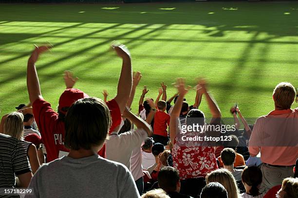 multi-ethnic fans standing, cheering in stands. baseball, soccer stadium. - baseball sport stock pictures, royalty-free photos & images