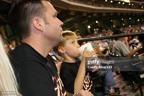 father and son at the baseball game. sports stadium. ballpark. - baseball stadium stock pictures, royalty-free photos & images